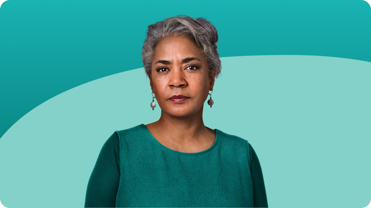 Older woman with short grey hair wearing a teal top