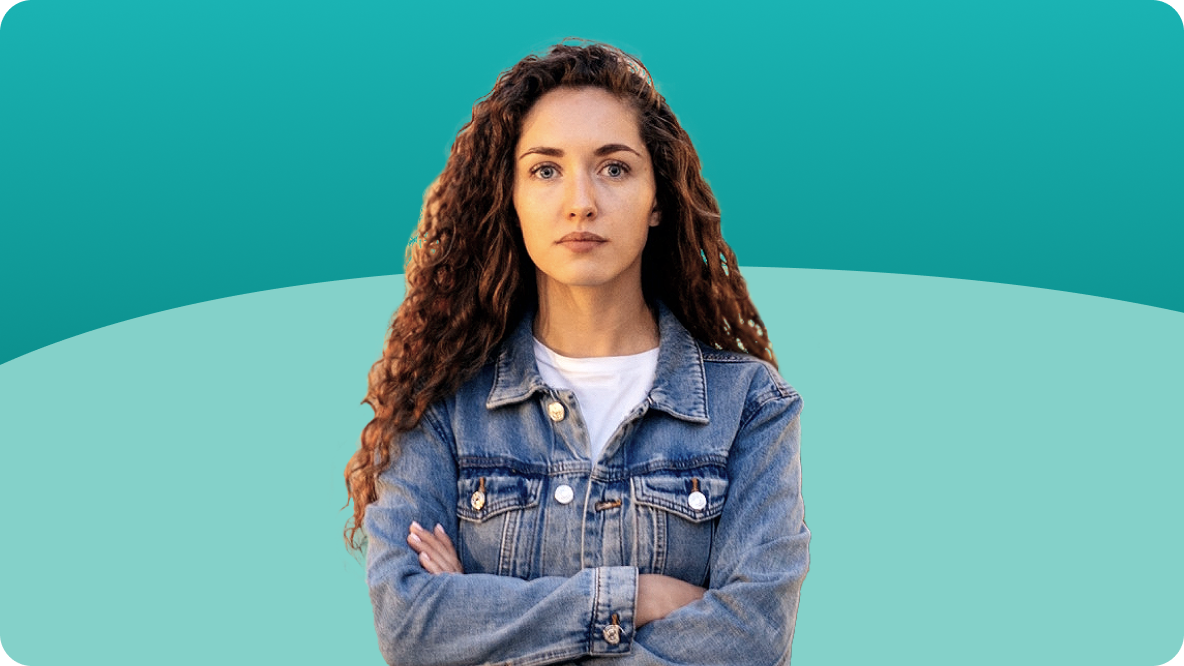 Young woman with long hair wearing a denim jacket, arms crossed
